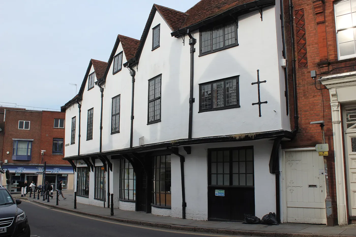 A timber-framed listed building on Guildford High Street with painted render and dark timbers