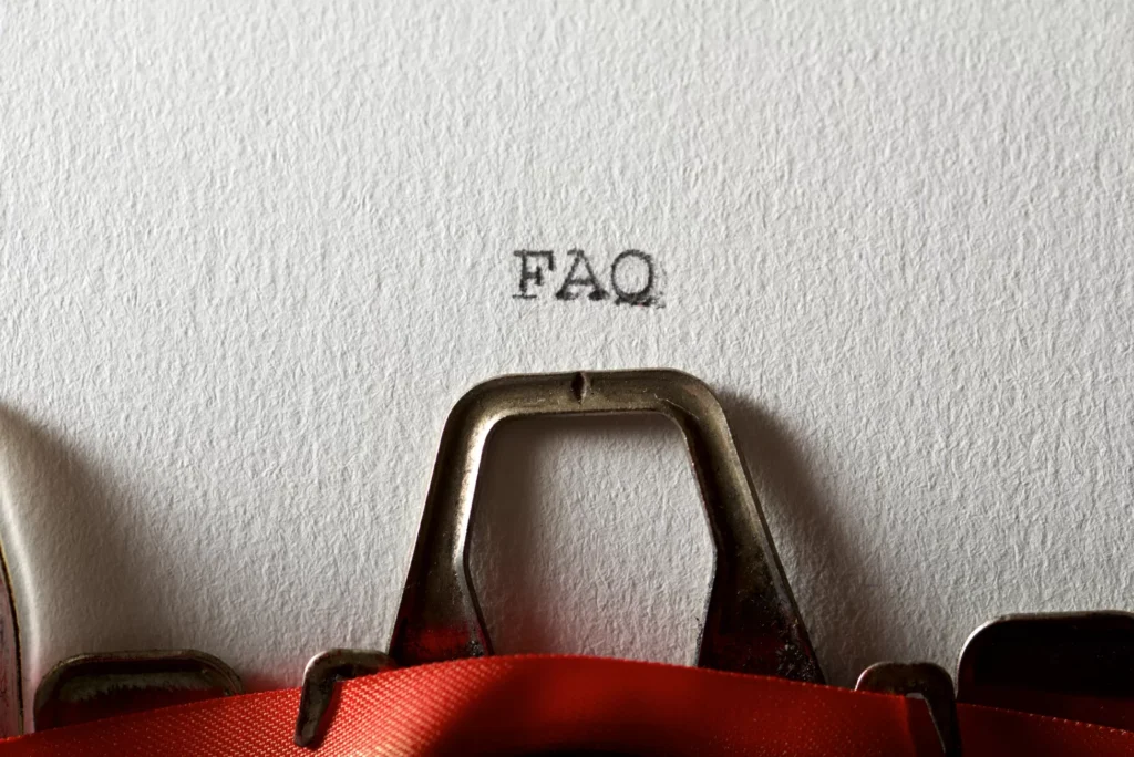 Close-up of a typewriter typing FAQ on white paper