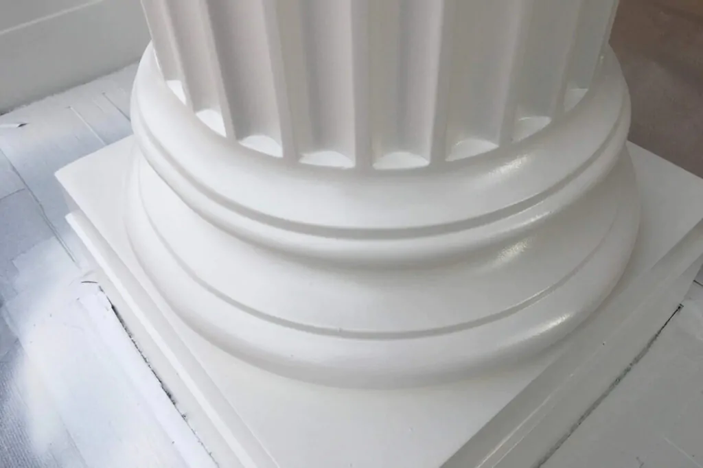 Masonry column and rendered surface sprayed in a light colour